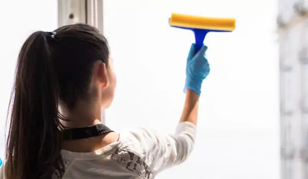 woman wiping a window glass