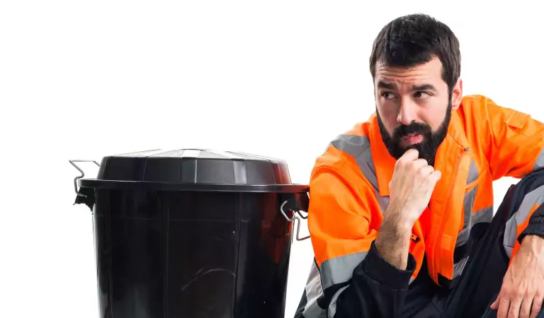 young man looking worried sitting with a trash can